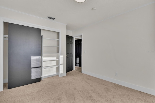 unfurnished bedroom featuring light colored carpet and a closet