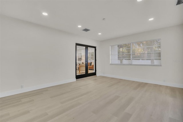 empty room with light hardwood / wood-style flooring and french doors