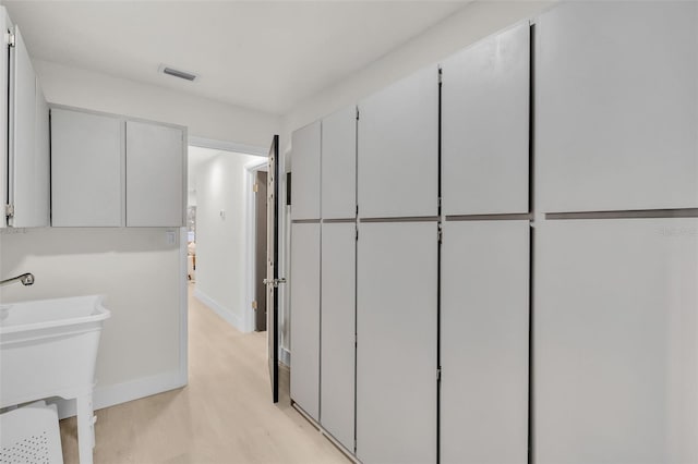 interior space with light hardwood / wood-style flooring and sink