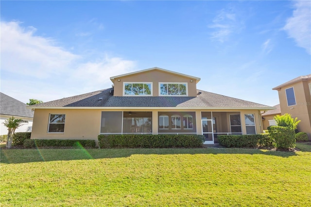 back of property with a yard and a sunroom