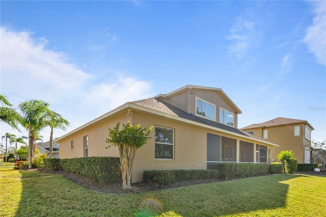 view of home's exterior featuring a lawn and a sunroom