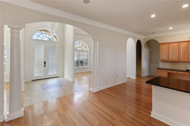 entrance foyer featuring crown molding, french doors, and light wood-type flooring