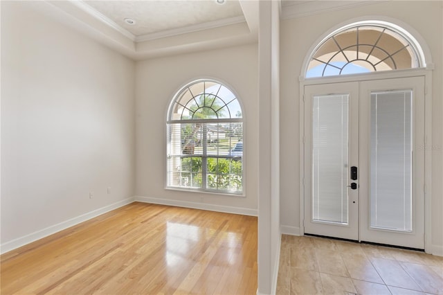 foyer entrance featuring ornamental molding, a wealth of natural light, and french doors