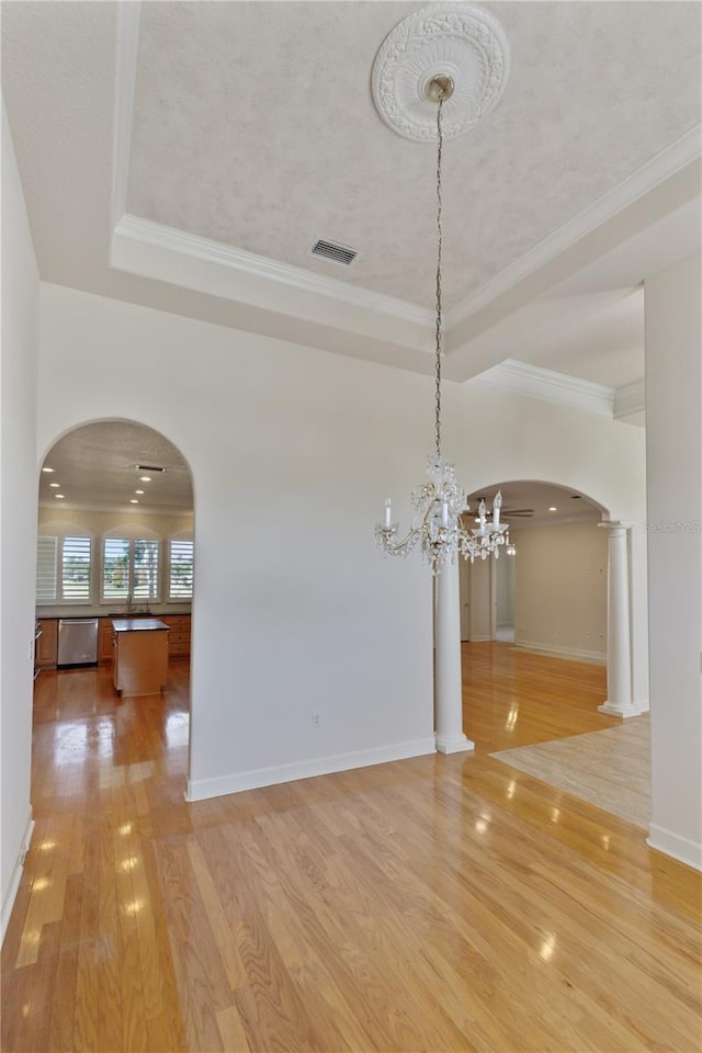 unfurnished dining area featuring crown molding, hardwood / wood-style floors, and an inviting chandelier