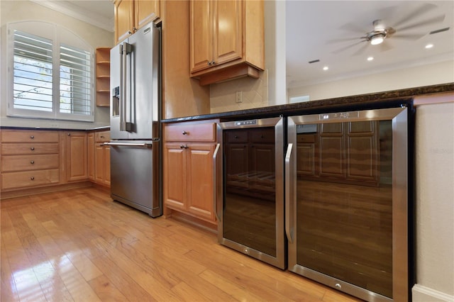 kitchen with high end refrigerator, crown molding, ceiling fan, and beverage cooler