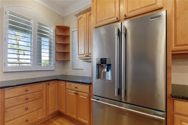 kitchen featuring backsplash, ornamental molding, light hardwood / wood-style flooring, dark stone countertops, and stainless steel fridge with ice dispenser