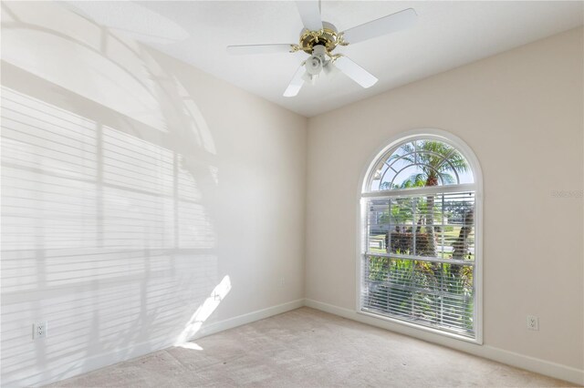 empty room featuring ceiling fan and light colored carpet