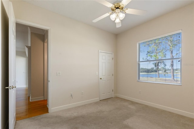 unfurnished room with light carpet and ceiling fan