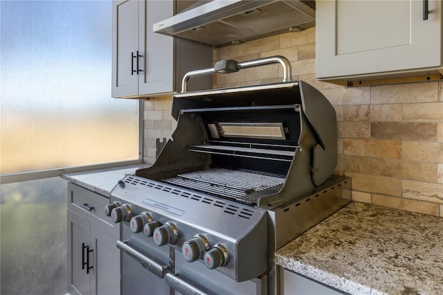 interior details with tasteful backsplash and wall chimney range hood