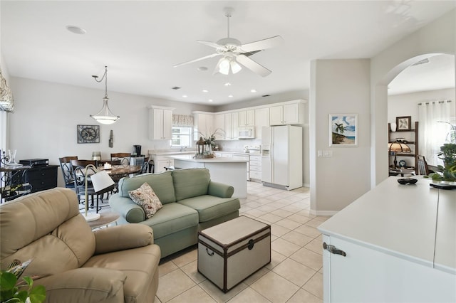 living room featuring ceiling fan, sink, and light tile patterned floors