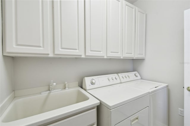 laundry area with cabinets, separate washer and dryer, and sink