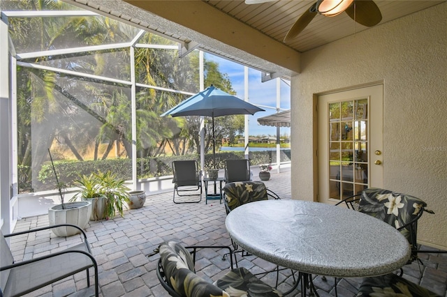 view of patio with ceiling fan and a water view