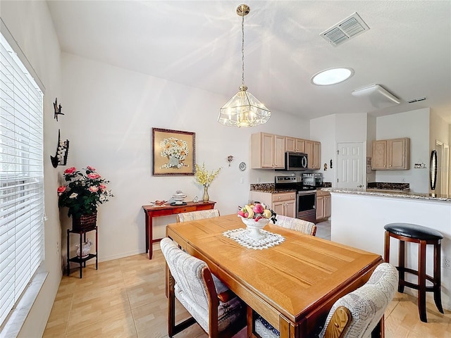 dining room with light tile patterned flooring and a chandelier