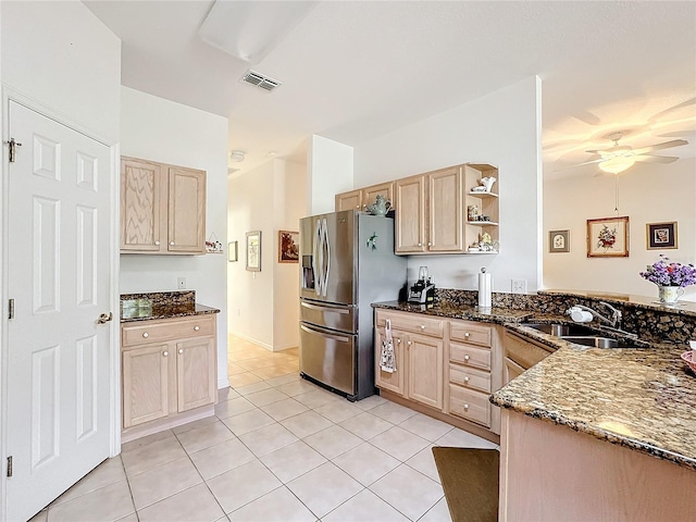 kitchen with stainless steel fridge with ice dispenser, light tile patterned floors, and light brown cabinetry