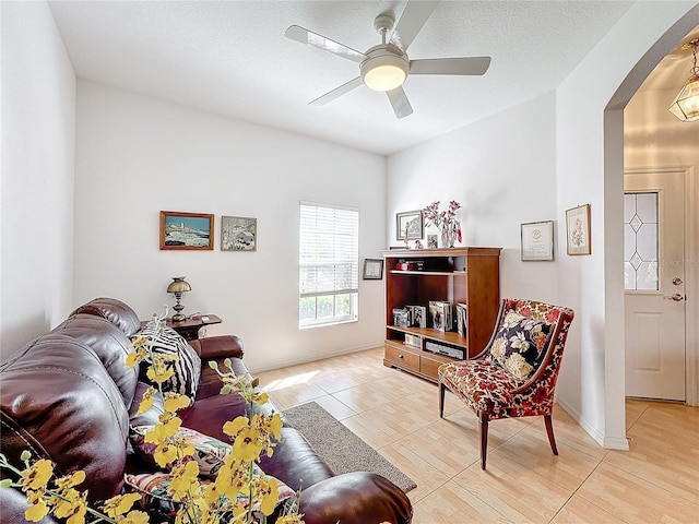 living room with ceiling fan and light tile patterned flooring