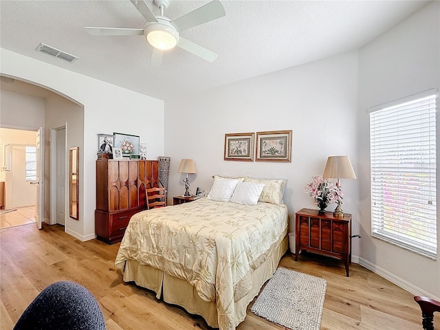 bedroom with ceiling fan, light hardwood / wood-style flooring, and ensuite bathroom