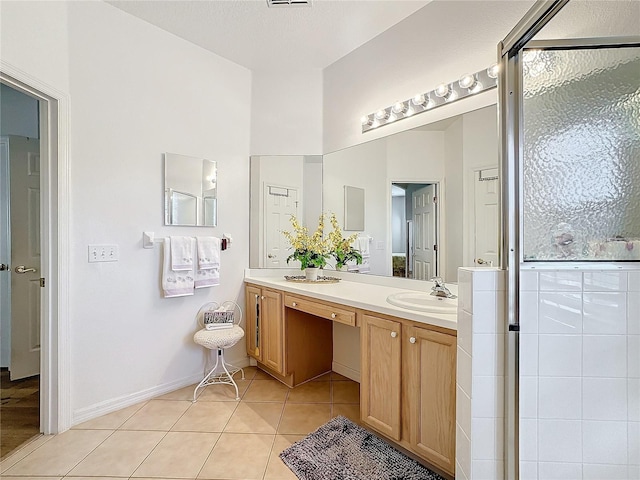 bathroom featuring tile patterned flooring, vanity, and a shower with shower door