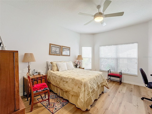 bedroom featuring a textured ceiling, light hardwood / wood-style floors, and ceiling fan