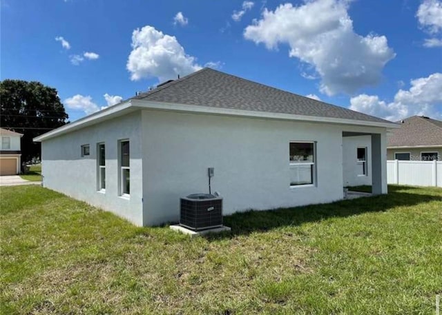 back of property featuring a lawn and central AC unit