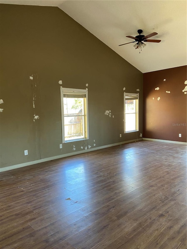 spare room with ceiling fan, plenty of natural light, high vaulted ceiling, and dark wood-type flooring