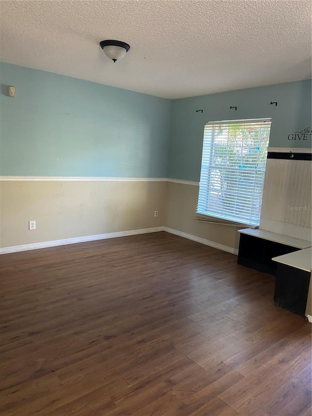 empty room featuring dark hardwood / wood-style flooring and a textured ceiling