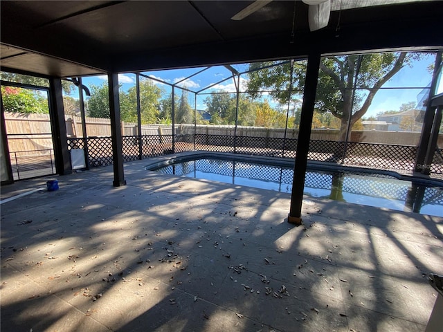 view of pool with a patio, glass enclosure, and ceiling fan