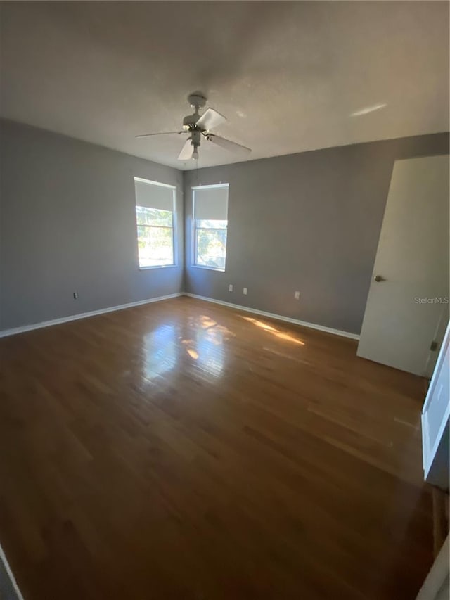 empty room featuring ceiling fan and dark hardwood / wood-style flooring