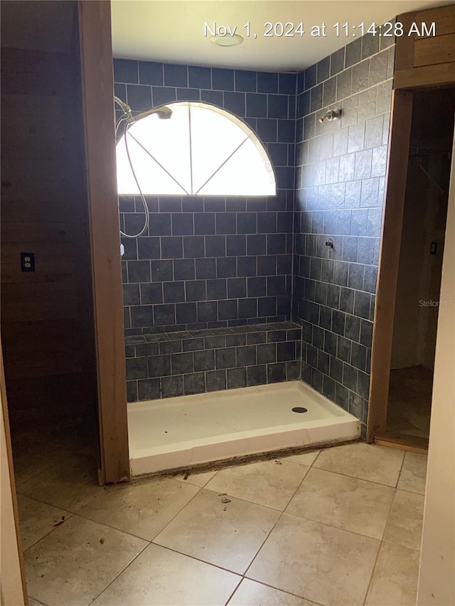 bathroom featuring tile patterned flooring and tiled shower