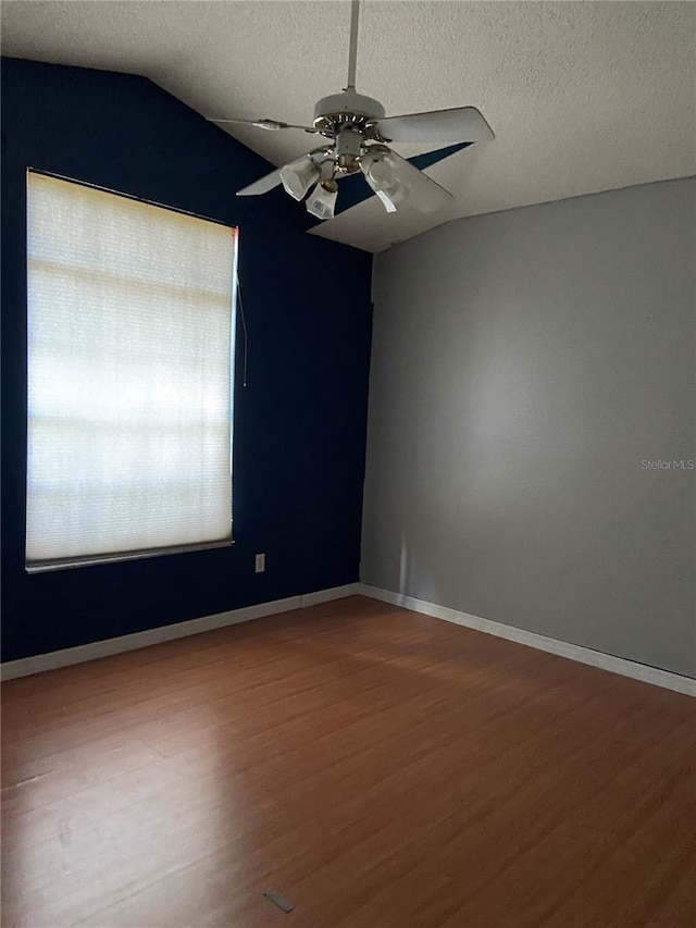 spare room featuring hardwood / wood-style floors, ceiling fan, a textured ceiling, and vaulted ceiling