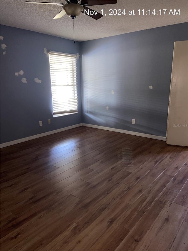 unfurnished room with ceiling fan, dark wood-type flooring, and a textured ceiling