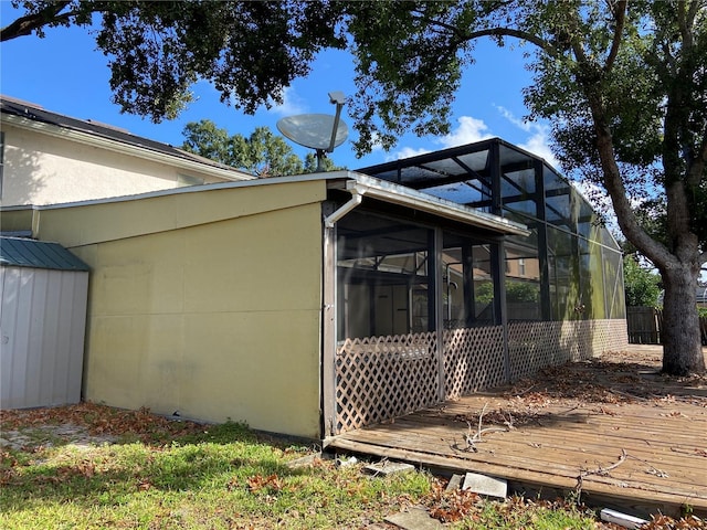 view of side of home with a lanai and a wooden deck