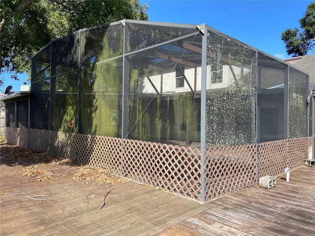 view of property exterior featuring a lanai and a wooden deck