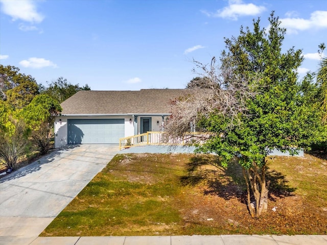 view of front of home featuring a front yard, a porch, and a garage