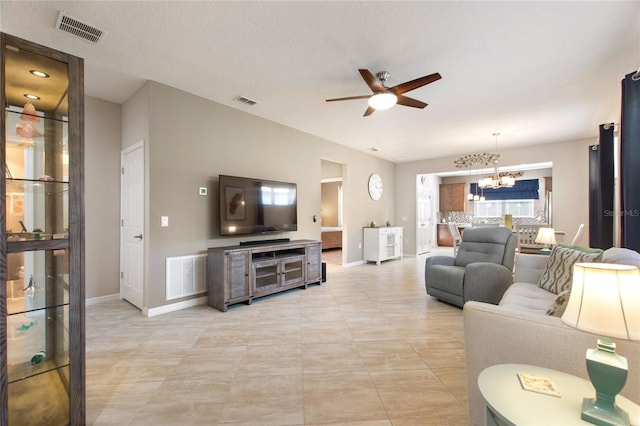 living room with ceiling fan with notable chandelier