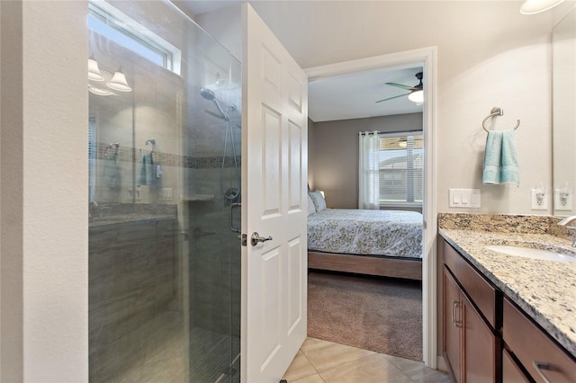 bathroom with tile patterned floors, ceiling fan, a shower with door, and vanity