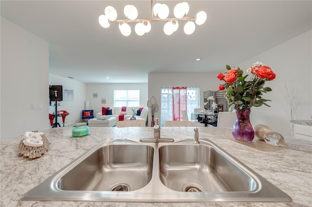 details with light stone counters, sink, and hanging light fixtures