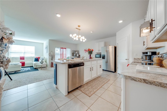 kitchen with light carpet, appliances with stainless steel finishes, a kitchen island with sink, decorative light fixtures, and white cabinetry