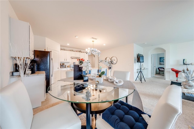 carpeted dining room featuring an inviting chandelier