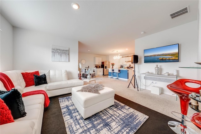 living room featuring carpet floors and a notable chandelier