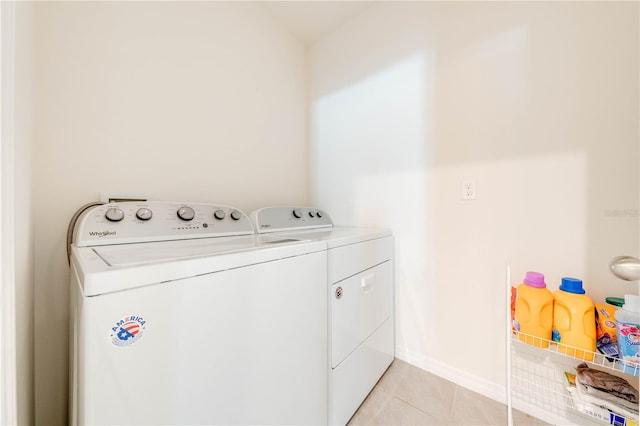 clothes washing area with light tile patterned floors and separate washer and dryer