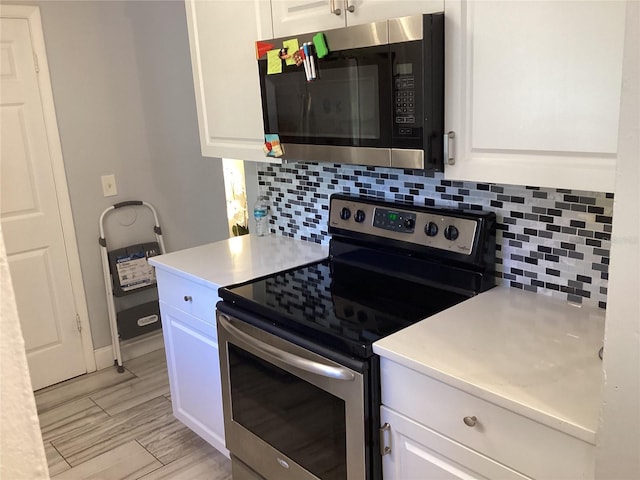 kitchen with tasteful backsplash, light countertops, appliances with stainless steel finishes, and white cabinets