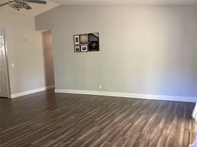 spare room with lofted ceiling, baseboards, a ceiling fan, and dark wood-style flooring