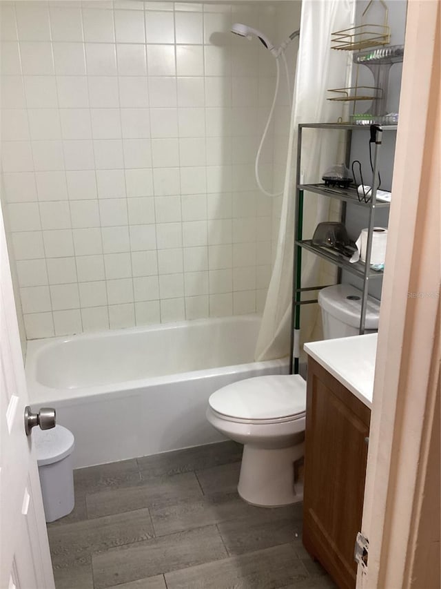 bathroom with toilet, shower / tub combo, wood finished floors, and vanity