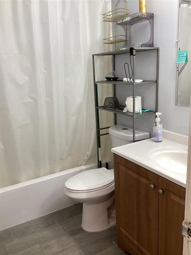 full bath featuring shower / tub combo with curtain, vanity, toilet, and wood finished floors