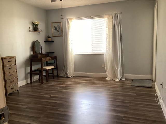 interior space with ceiling fan, baseboards, and dark wood-style flooring