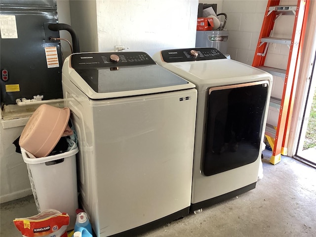 washroom with washer and dryer, laundry area, and concrete block wall