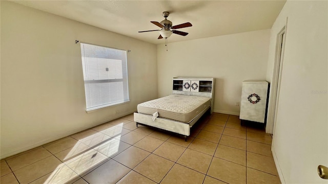 bedroom with a ceiling fan, baseboards, and light tile patterned floors