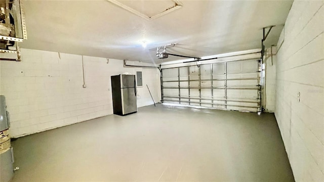 garage featuring a garage door opener, freestanding refrigerator, electric panel, and concrete block wall