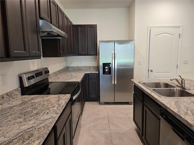 kitchen with sink, light tile patterned floors, appliances with stainless steel finishes, light stone counters, and dark brown cabinetry