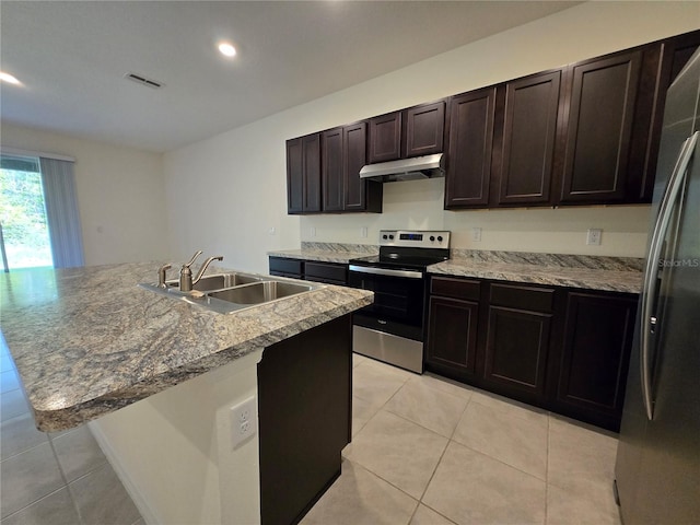 kitchen featuring dark brown cabinetry, sink, a kitchen island with sink, light tile patterned floors, and appliances with stainless steel finishes